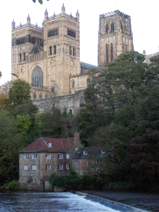 a large old building is standing near a river