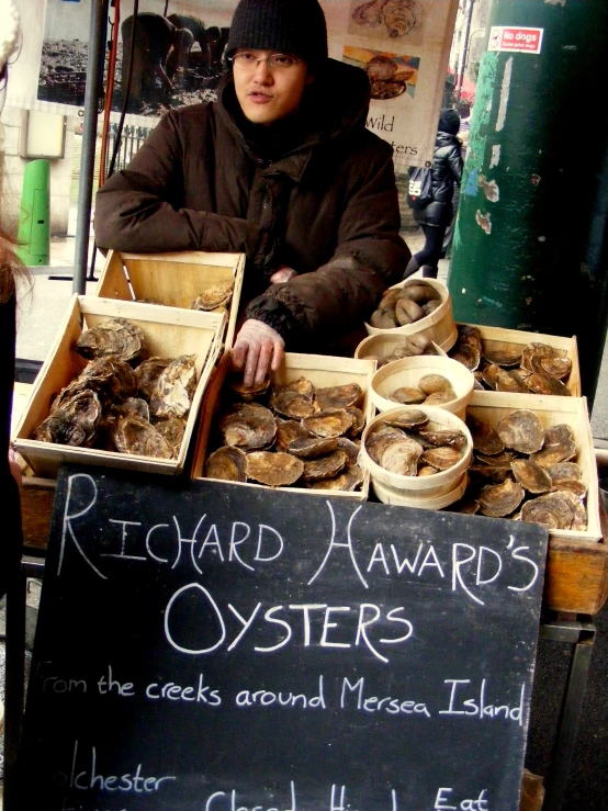 a man sitting at a table that has oysters on it