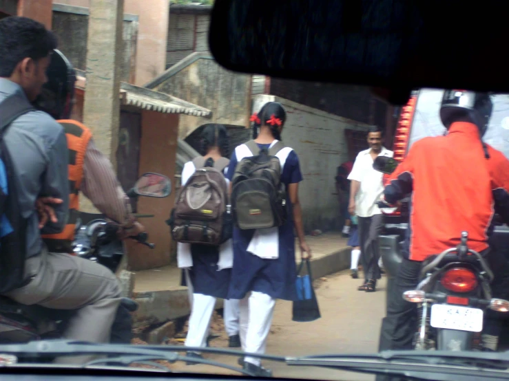 a boy is crossing the street in front of two women with luggage