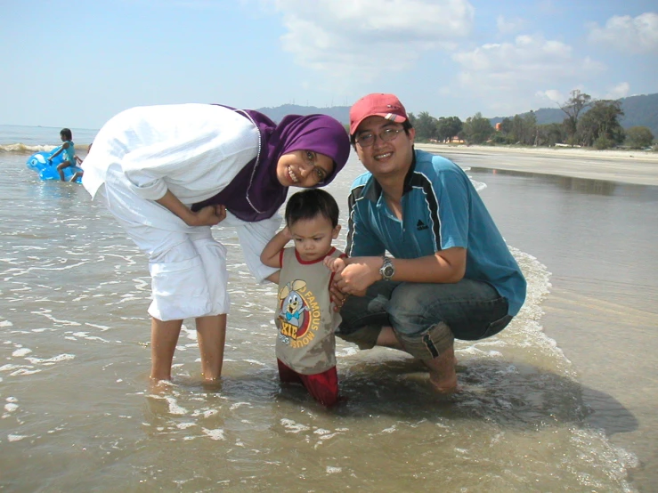 a couple with their child on a beach