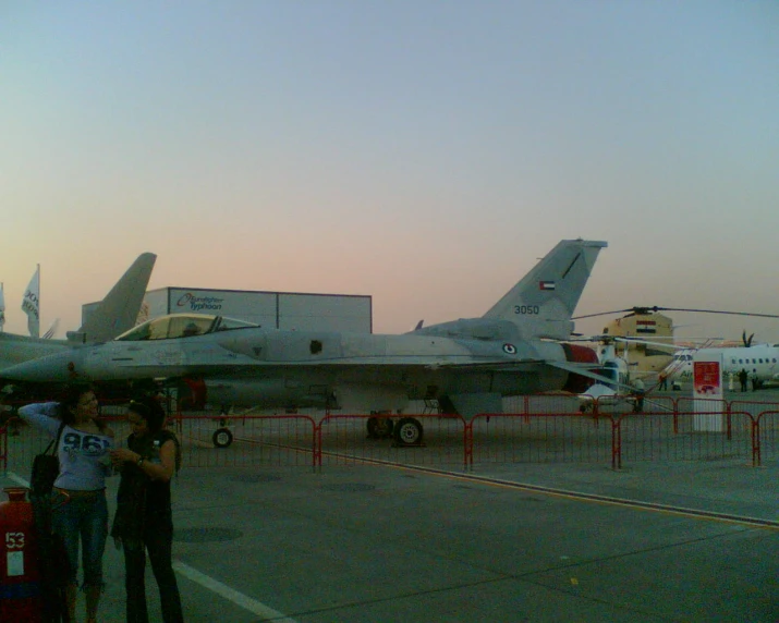 two people looking at an airplane on the runway