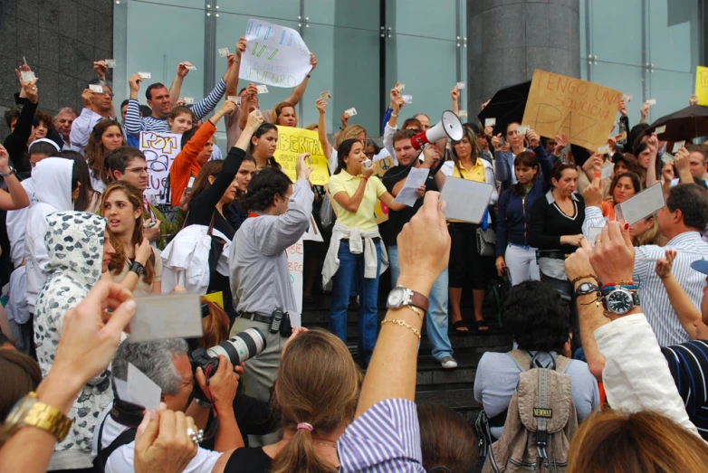 people standing in a crowd with some holding signs