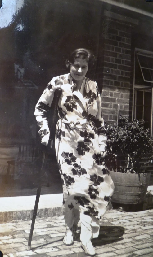 an old fashion po shows a woman in a long dress holding a stick