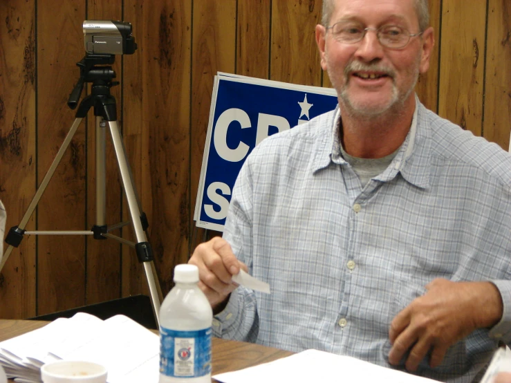 a man is smiling while holding a cellphone