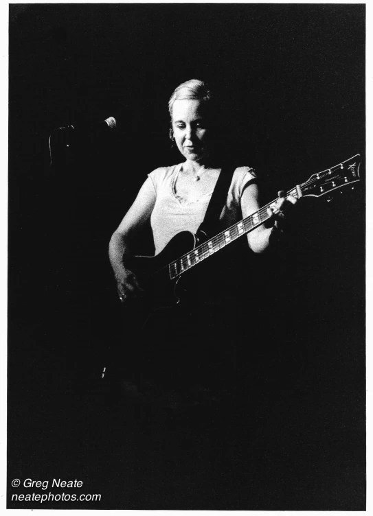 the girl is playing a guitar in the dark