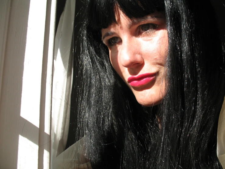 a person with long hair and bangs in the sun