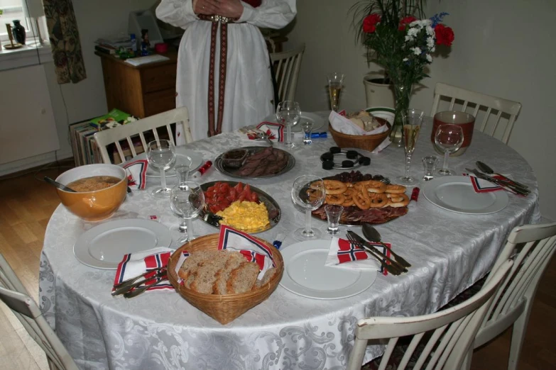 a lady is standing behind her dining table