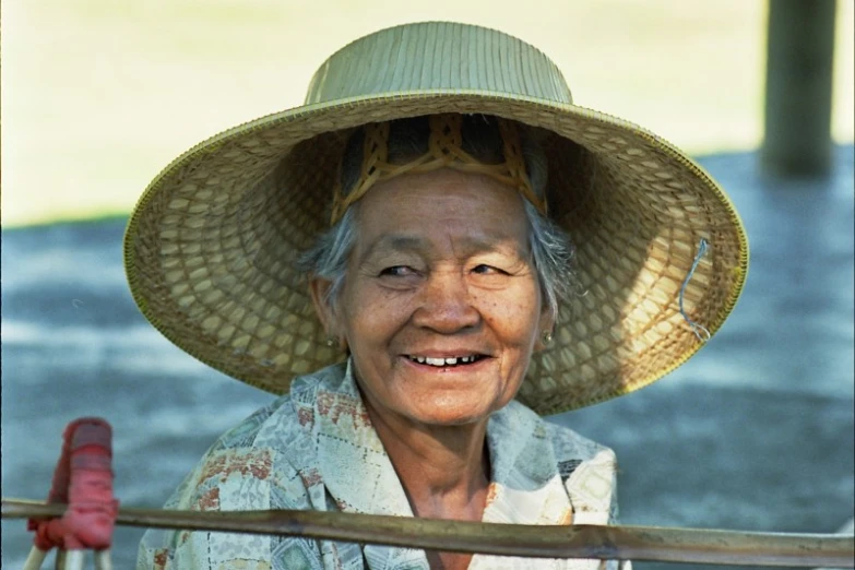 an old asian woman wearing a straw hat