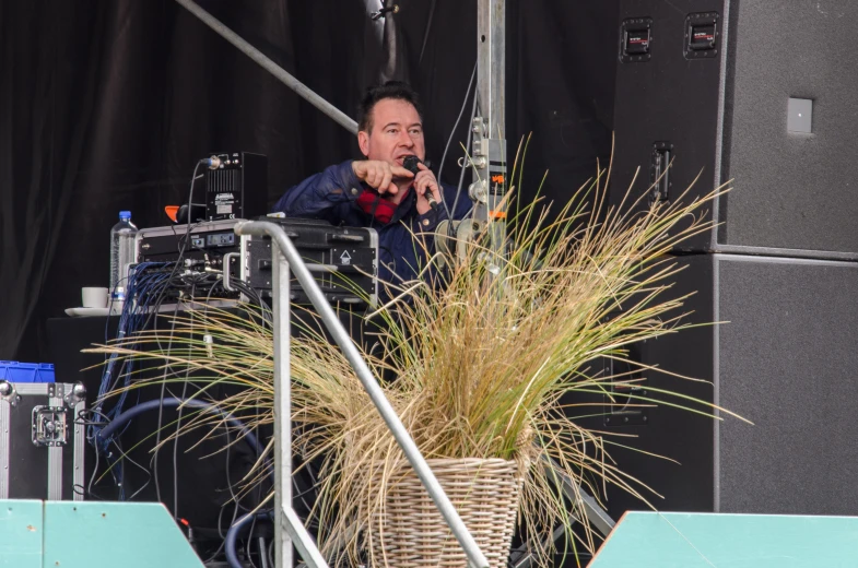 a man points at a giant plant while another stands next to him