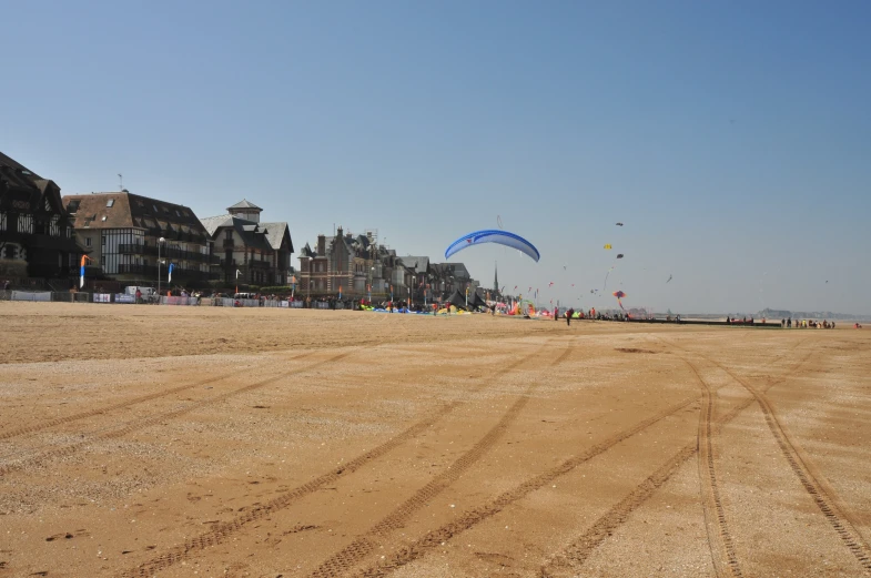 several kites flying over some sand on the beach