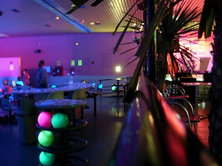 a room filled with tables and chairs covered in neon lights