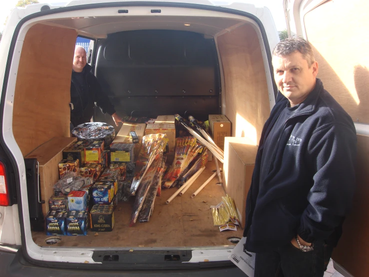 the man is in the back of the truck with the boxes