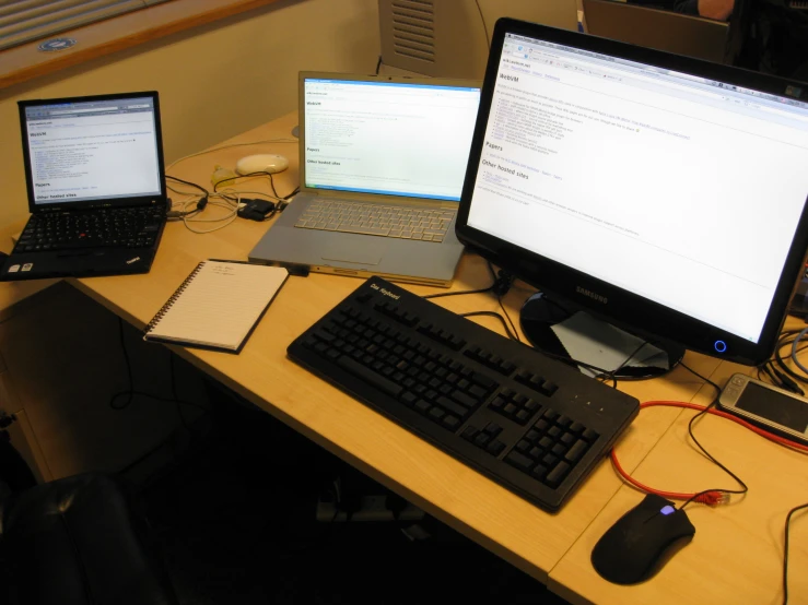 a table with two computers on it next to a keyboard