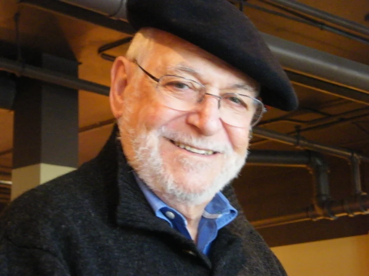 an older man with a black hat and blue shirt