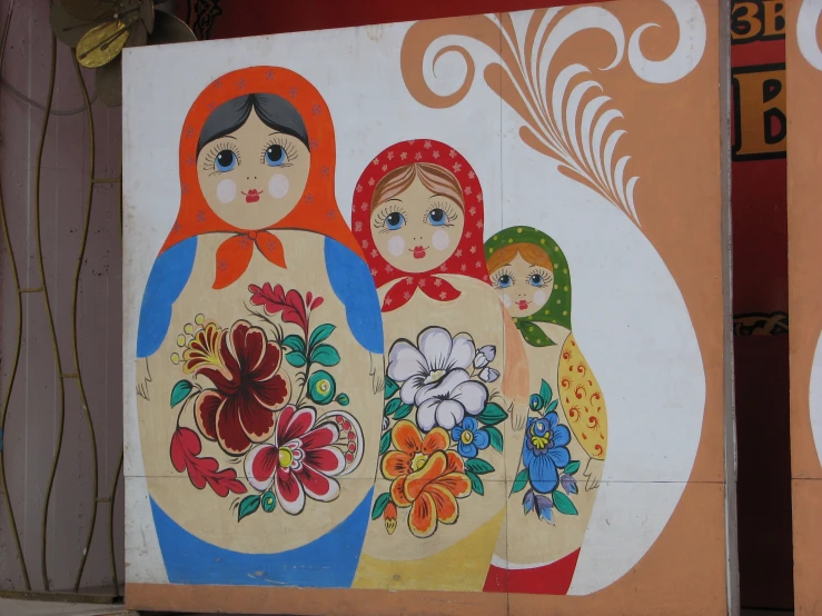 a wall painting of three ladies in the middle of the street