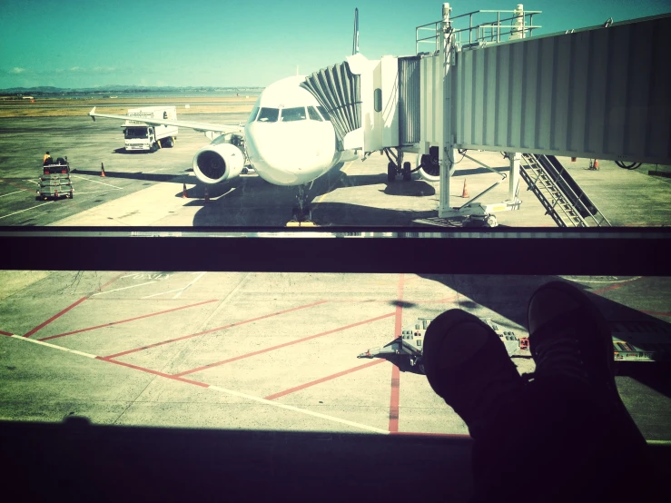 a person is standing next to the gate on an airport tarmac