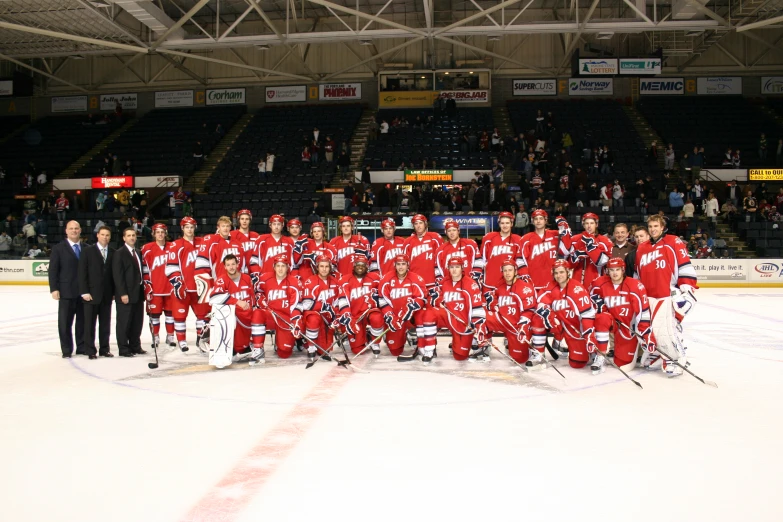 hockey players posing for a team po in an arena