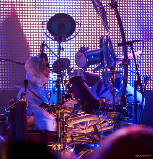 a drummer sitting behind a drum set with a microphone