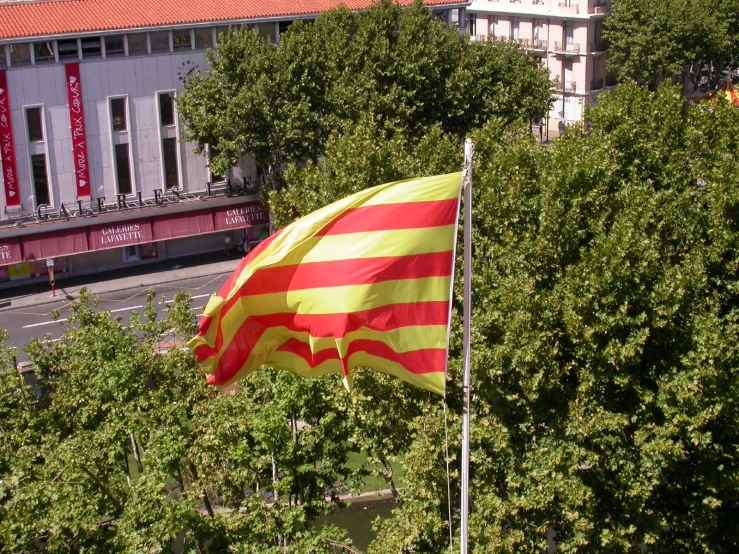 large striped and red flag in front of a city street