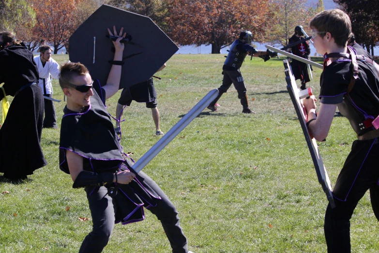 there are people on the field playing with swords