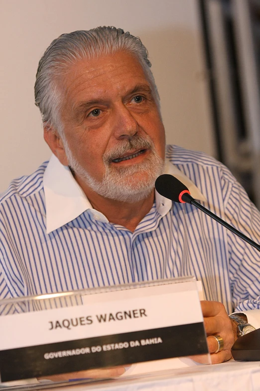 an older man speaking at a podium with microphone