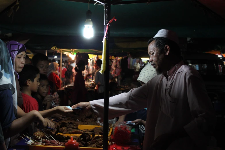 a person holding food while others look on