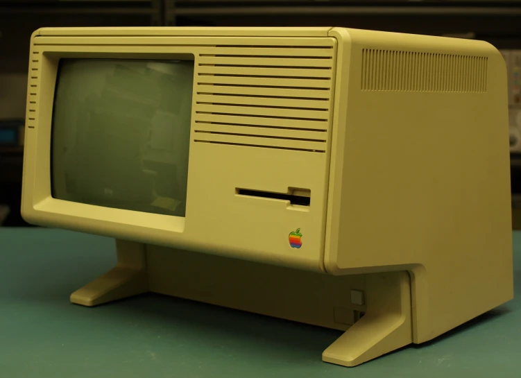 a yellow apple computer with a black macintosh logo on it