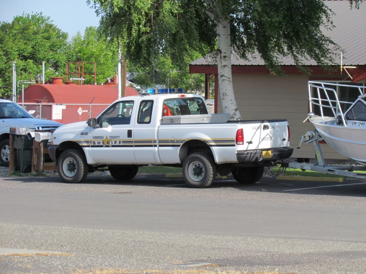 a white truck towing a boat on the trailer