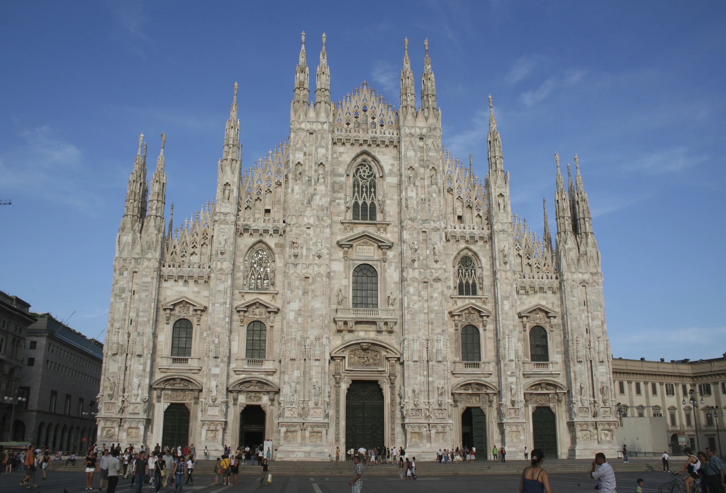 a group of people standing around the entrance to a building