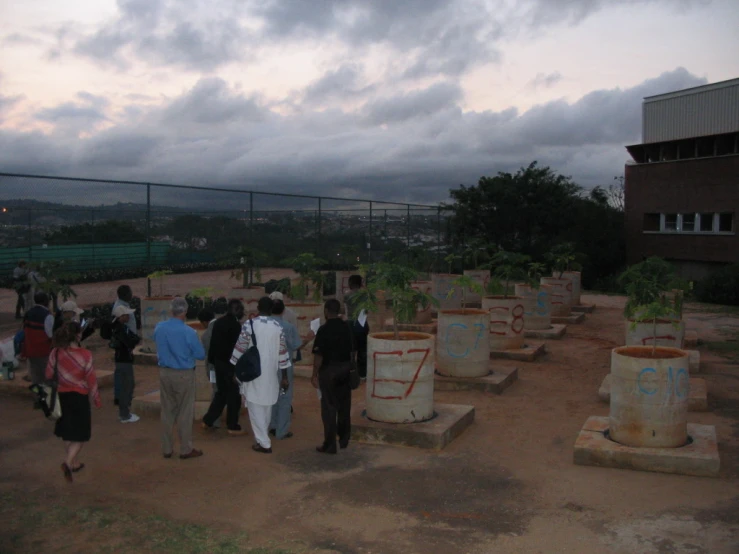 a group of people are standing in front of some plant pots