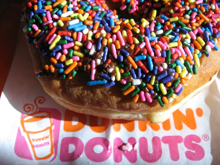 a donut covered in sprinkles with a cup of dunkin's juice