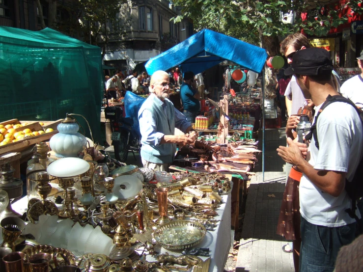 people at an outdoor market with antiques for sale