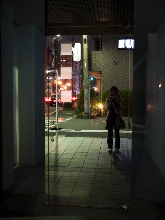 a person standing in the doorway of a dark street at night