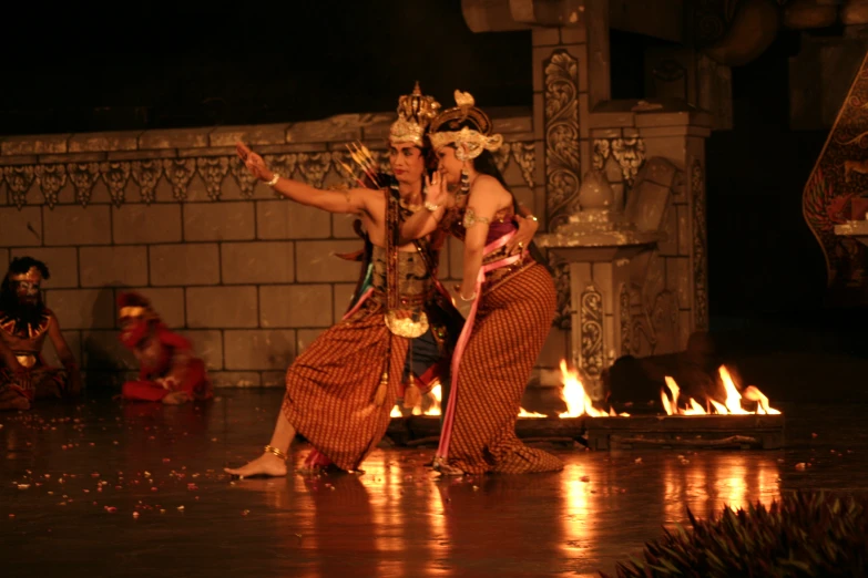 two people dancing in the rain with torches on