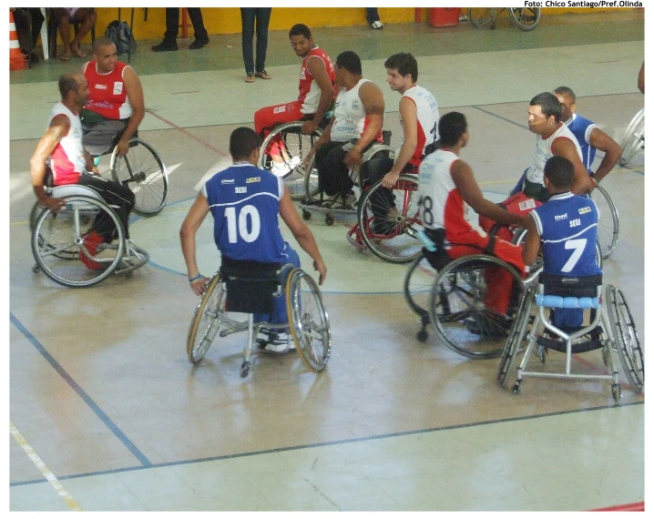 a group of young people in wheelchairs on a gym court