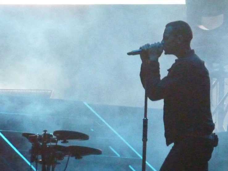 a man standing in front of a microphone on top of a stage