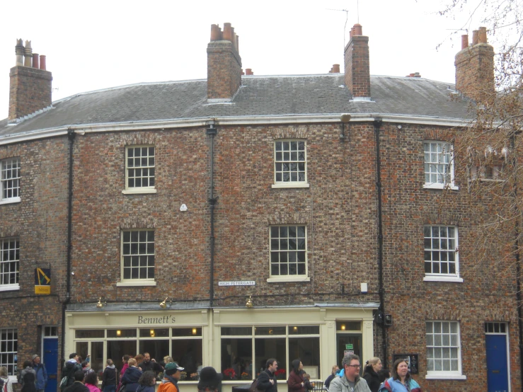 a crowd of people walking around in front of a building