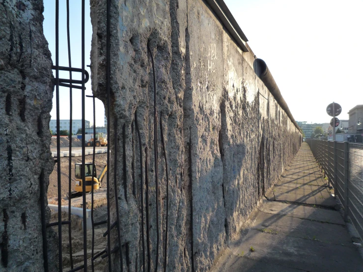 there is a metal gate behind the stone wall