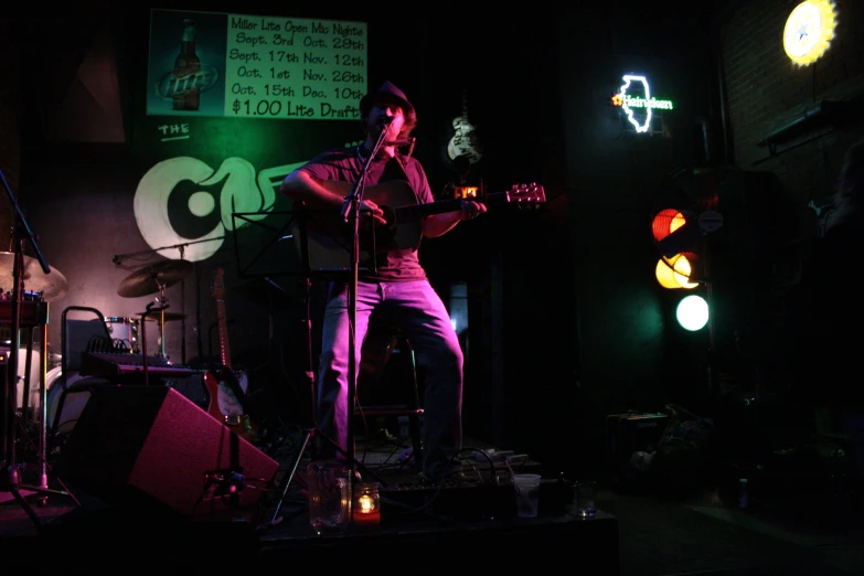 a person that is playing a guitar in the dark