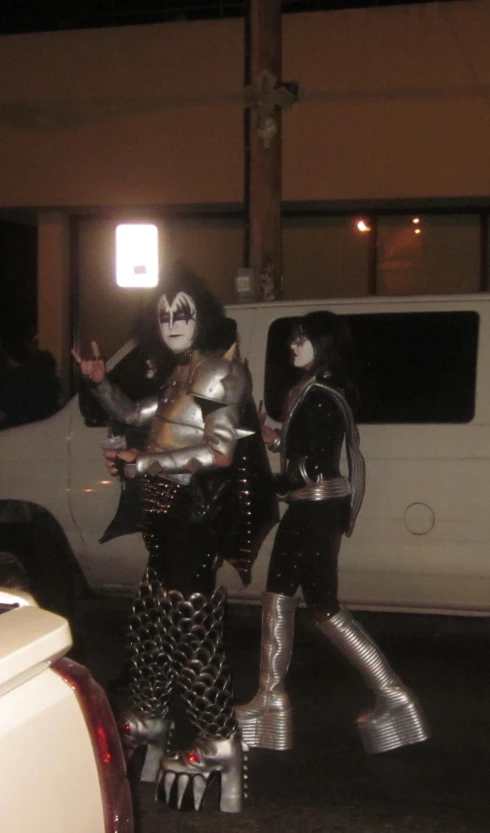 two people wearing costumes standing next to a white truck