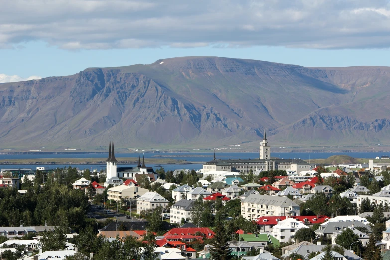 a town and mountains are shown with clouds