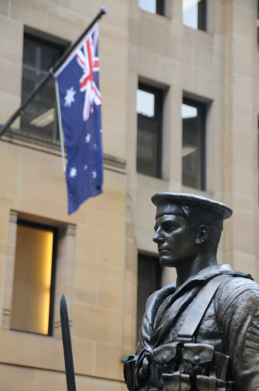 a statue of an officer with a sword stands in front of a building