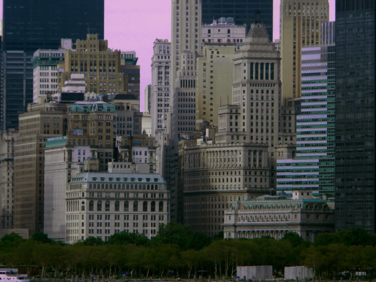 a boat sailing along a harbor next to tall buildings