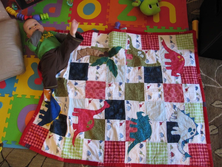 a child laying on a colorful patchwork rug