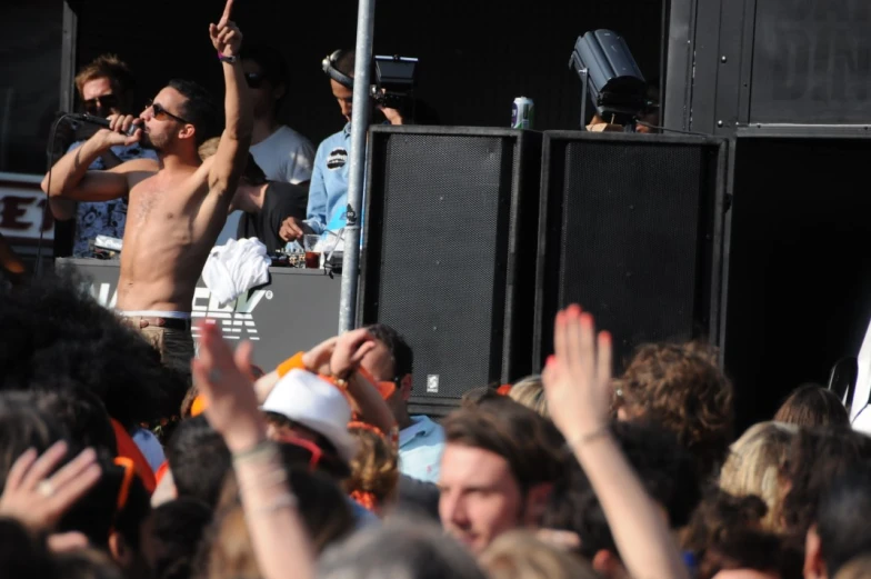 a group of men standing around while one holds his arms in the air