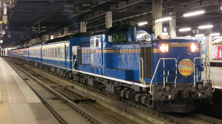 a train in a big station with the lights on