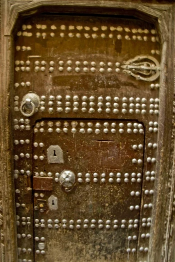 the door to a wooden structure is painted with many holes
