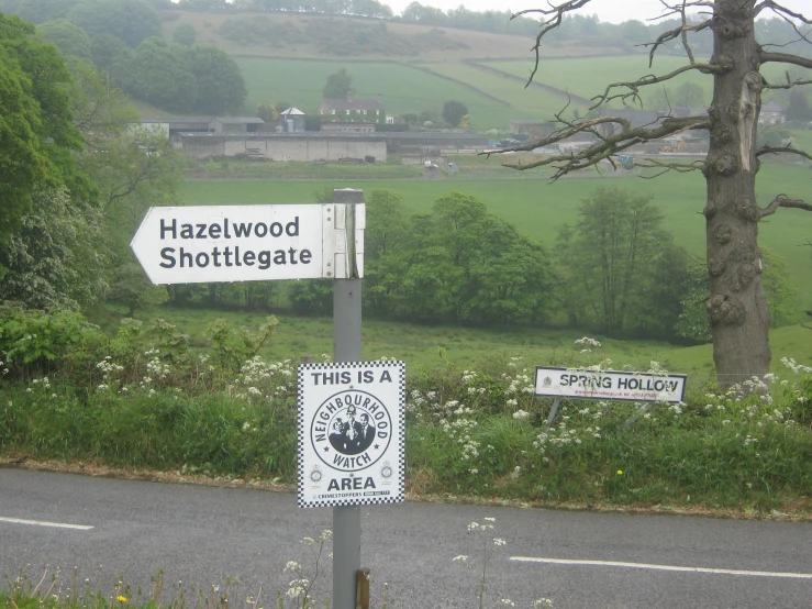 a road sign with three signs near the side of it