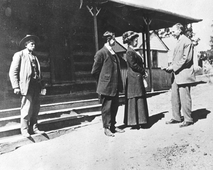 three men are standing outside an old train station