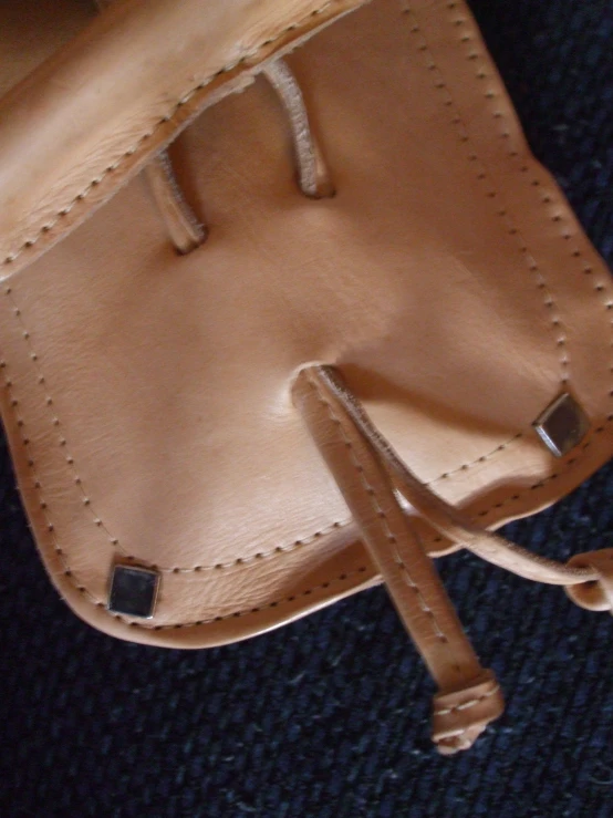 a brown pouch sitting on top of a chair